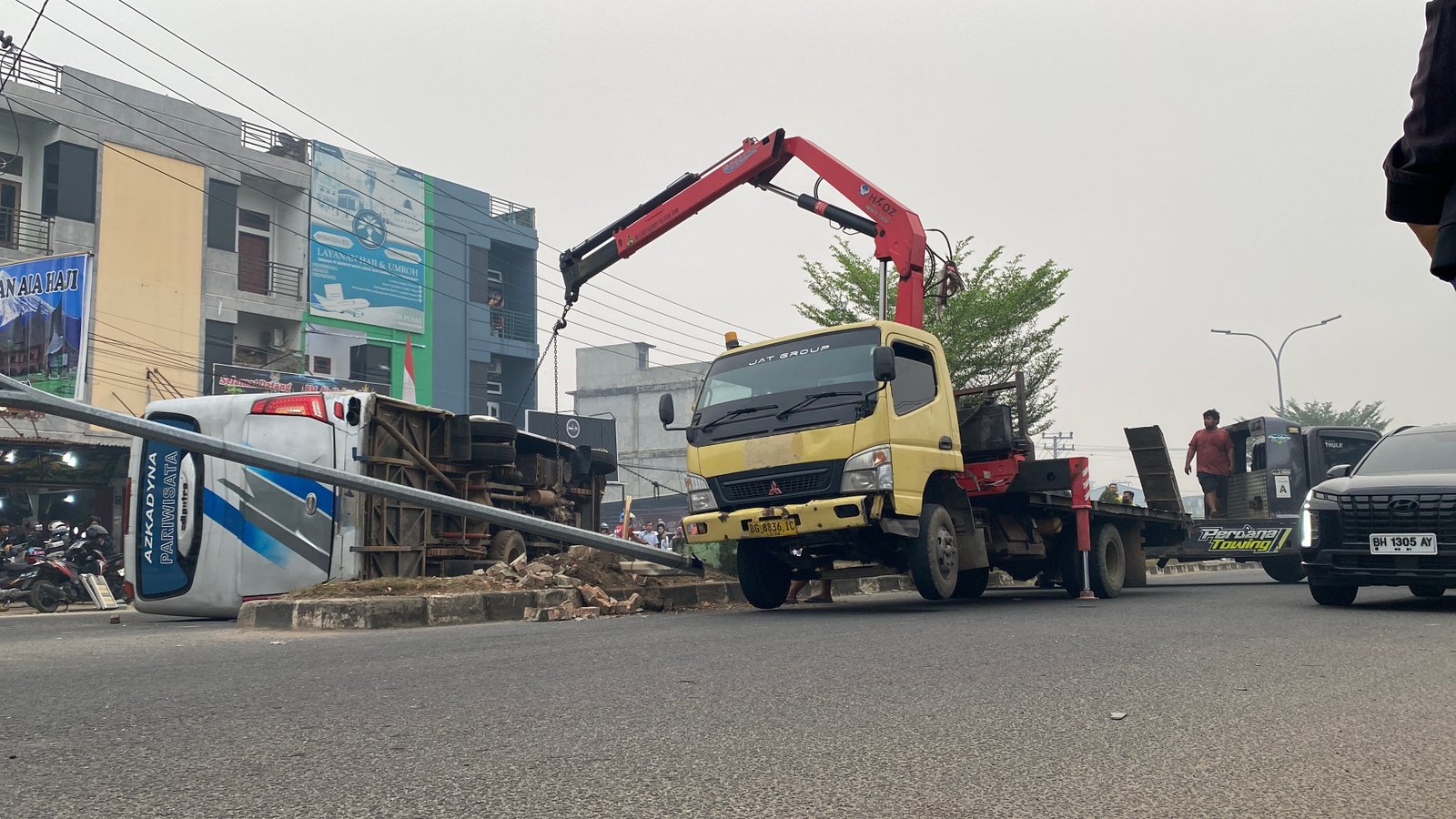 Minibus terguling di kawasan Simpang Rimbo, Kenali Besar, Kota Jambi, setelah diduga menghindari sepeda motor yang memutar arah (Gracak.com/Yanto).