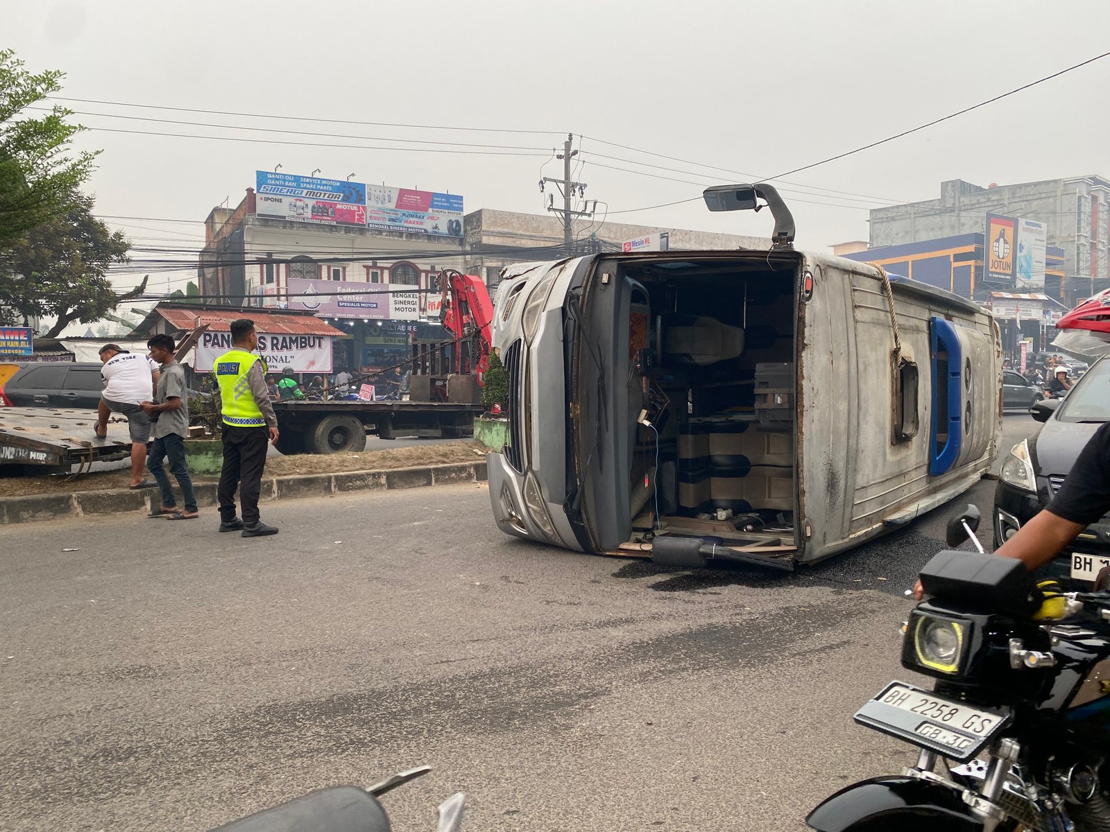 Minibus terguling di kawasan Simpang Rimbo, Kenali Besar, Kota Jambi, setelah diduga menghindari sepeda motor yang memutar arah (Gracak.com/Yanto).