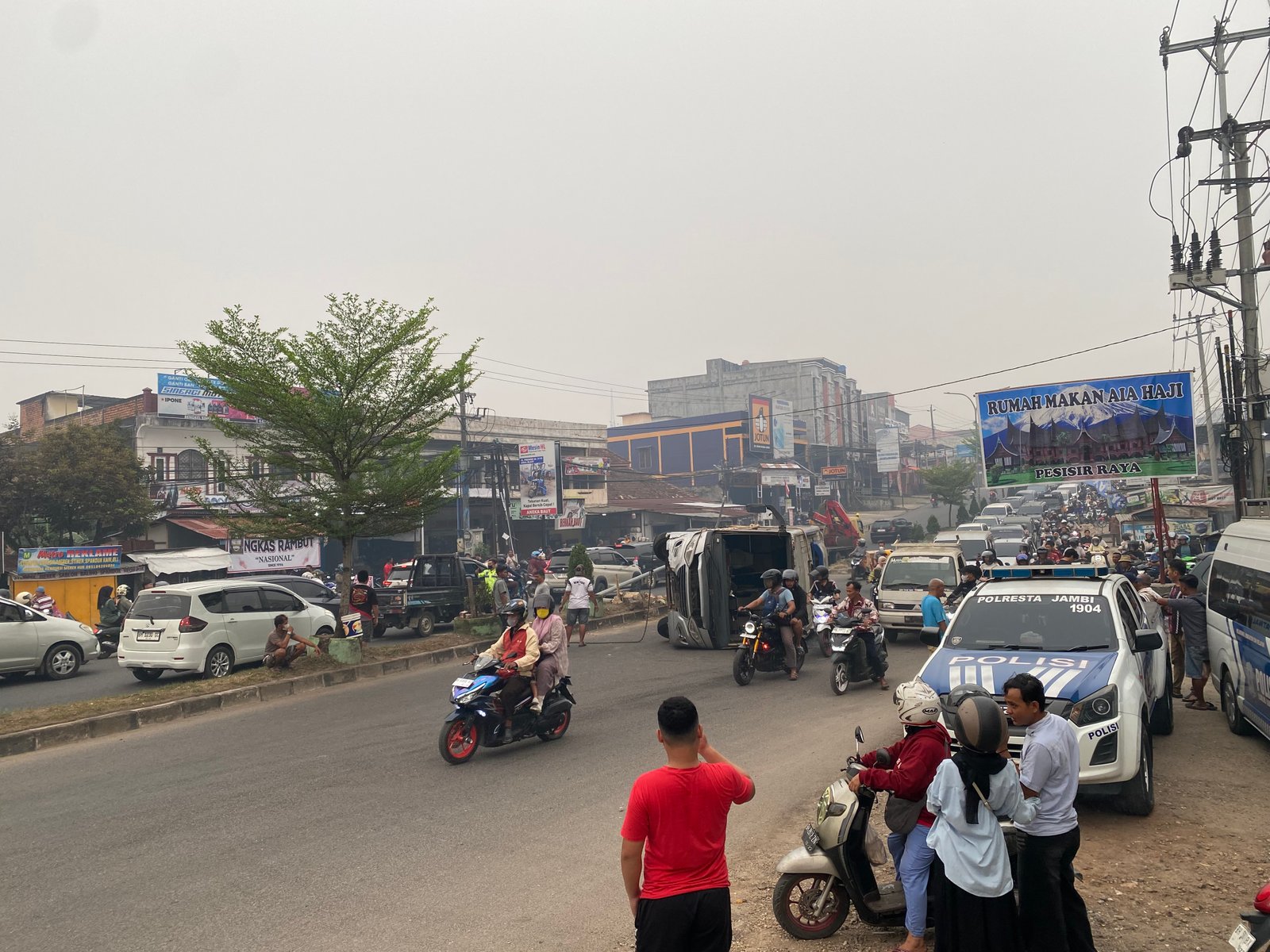 Minibus terguling di kawasan Simpang Rimbo, Kenali Besar, Kota Jambi, setelah diduga menghindari sepeda motor yang memutar arah (Gracak.com/Yanto).